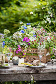 Üppiger Strauß Wildblumen in einer Holzkiste als Tischdeko