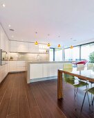 Dining table and wood-effect tiles in open-plan kitchen