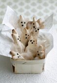 Easter bunnies made of pizza dough with white feathers and napkin in a basket