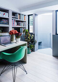 Study room with bookcase, desk and green shell chair