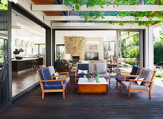 Upholstered wooden armchairs under the overgrown pergola