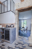 Concrete kitchen counter and patterned floor continuing into dining room