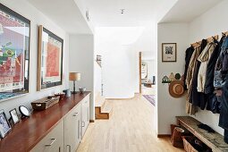 Garderobenbereich mit Sideboard und Wandgarderobenleiste, Blick in offenen, hellen Wohnbereich