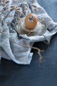 Easter egg decorated with animal sticker on pewter saucer