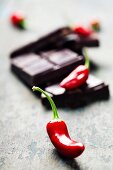 Dark chocolate with chili pepper over wooden background