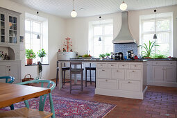Kücheninsel mit Tresen in heller Wohnküche im Landhausstil
