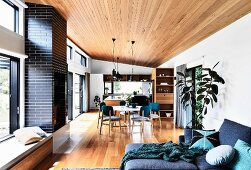 Open living area with parquet flooring, wooden ceiling and glass front to the terrace