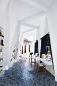 Elegant work area with two desks, white built-in shelves and mosaic tiled floor