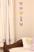 Garland of Easter motifs on wall next to curtain with tulip motifs