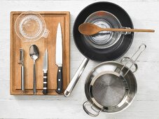 Various kitchen utensils: pot, strainer, pan, measuring cup, citrus press
