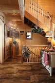 Rustic stairwell, wood oven and standard lamp in wooden Alpine house