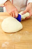 A piece of dough being cut off with a dough scraper (firm dough)