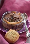 Baked chocolate pudding with salted caramel sauce in a glass ramekin