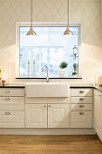 White country-house kitchen with diamond-patterned wallpaper and large window