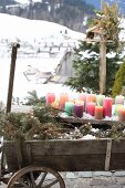 Colourful pillar candles on weathered wooden board outdoors