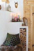 Masonry fireplace with colourful pillar candles on wooden stands
