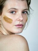 Portrait of a woman with face mask on her cheek