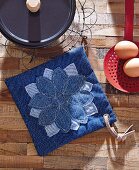 A denim pot cloth decorated with a two-layer embroidered flower