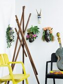 Various ethnic animal masks decorated with flowers and coat stand made from wooden props between armchairs