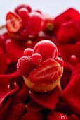 Mini tarts with red fruits on rose petals
