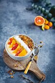A smoothie bowl with citrus fruits and coconut flakes