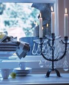 Mehrarmiger, schwarzer Kerzenständer mit brennenden Kerzen und Glasschmuck