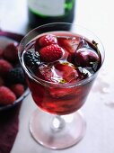 Sangria with red berries and ice cubes