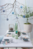 Weihnachtliche Tischdekoration mit geschmücktem Zweig