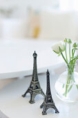 Two small Eiffel towers next to vase of ranunculus