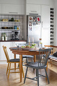 Gedeckter Esstisch mit verschiedenen Stühlen und Bank in der Küche