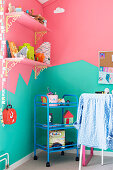 Kinderzimmer mit zweifarbig gestalteter Wand in Mint und Pink