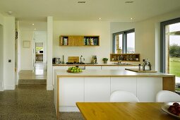 White, modern open-plan kitchen without wall units