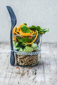 Spaghetti salad with cucumber, spinach and spiralized carrot in a glass