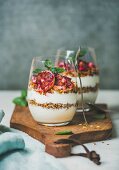 Healthy breakfast. Greek yogurt, granola, blood orange layered parfait in glasses with fresh mint