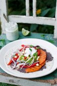 Wrap (tortilla) with black beans paste, roasted pepper, roasted sweet potato, avocado, corn grains, red onion and mint yoghurt sauce