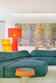 Blue sofa and colourful artwork in artistic living room