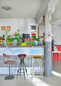 Breakfast bar, column and colourful eclectic furnishings in loft apartment