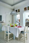 Set table and colourful glass crockery on white wooden floor in dining area