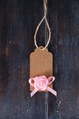 Brown paper tag with pink fabric rose and ribbon