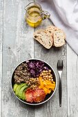 A veggie bowl with quinoa, chickpeas, avocado, peppers, red cabbage and blood oranges