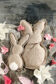 Two fabric rabbits with zig-zag edge and paper flowers