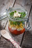 Fusilli with tomato sauce, mozzarella and rocket in a glass jar