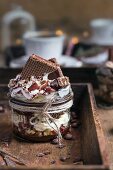 Mascarponedessert mit Schokoladenkeksen, Haselnüssen, Kakaopulver und Schlagsahne im Glas