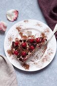 Tiramisu with cherry and chocolate on a white plate