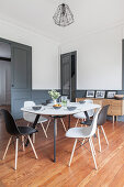 Dining table and chairs in interior with white walls and dove grey wainscoting