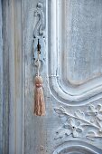 Schlüssel mit Quaste an antiker, kunsthandwerklicher Holztür