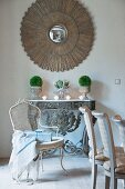 Artistic mirror on wall above festive arrangement on antique console table