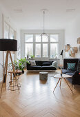 Standard lamp, sofa set, coffee table and houseplants in period apartment