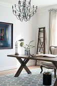 Wooden table and chandelier in elegant study