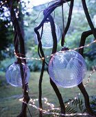 Transparent, patterned glass baubles and fairy lights hung amongst branches